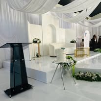 Draped stage with podium and lounge seating
